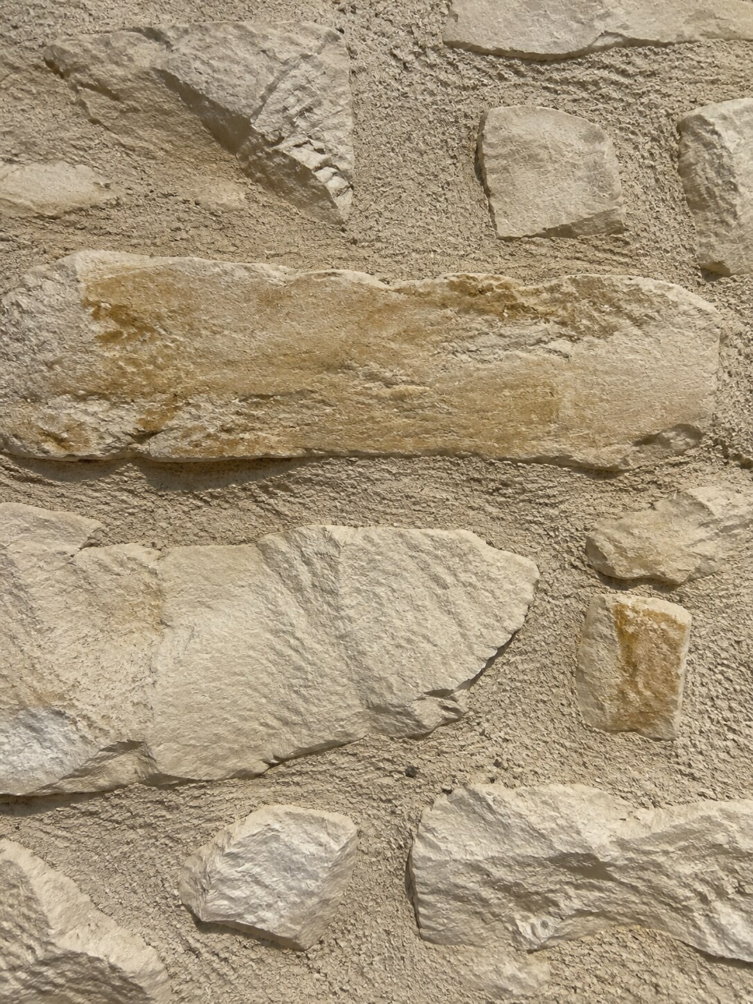 Détail de pierres calcaires ivoire et miel avec joint ancien sable-gris, création Moellons de Bengy